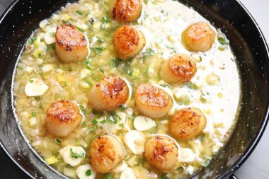 Gri masada soslu kızarmış istiridye, üst tarafta.