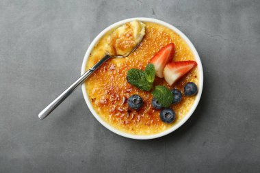 Böğürtlenli ve nane şekerli nefis creme brulee gri masada, üst manzara