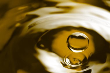 Arka plan olarak damla altın yağlı sıvı, yakın çekim. Metin için boşluk