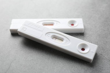 Gri masada iki adet tek kullanımlık test, yakın plan.