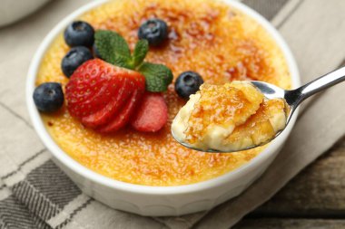Böğürtlenli ve nane şekerli nefis creme brulee 'yi ahşap masadan alıp, yakın plan