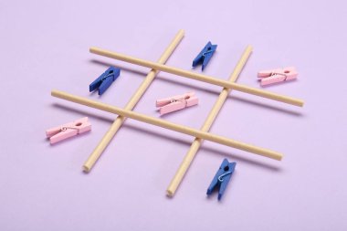 Leylak arkaplanındaki mandallarla yapılan tik tak parmak oyunu