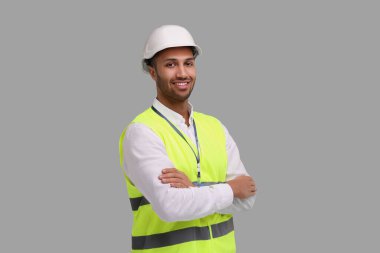 Gri arka planda sabit şapkalı mühendis.