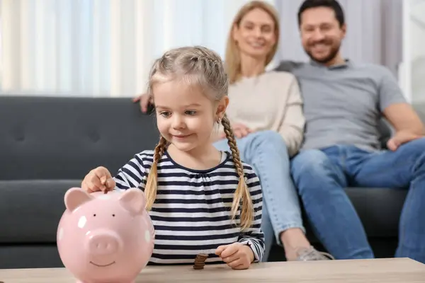 Familiebudget Klein Meisje Zet Munt Spaarvarken Bank Terwijl Haar Ouders — Stockfoto