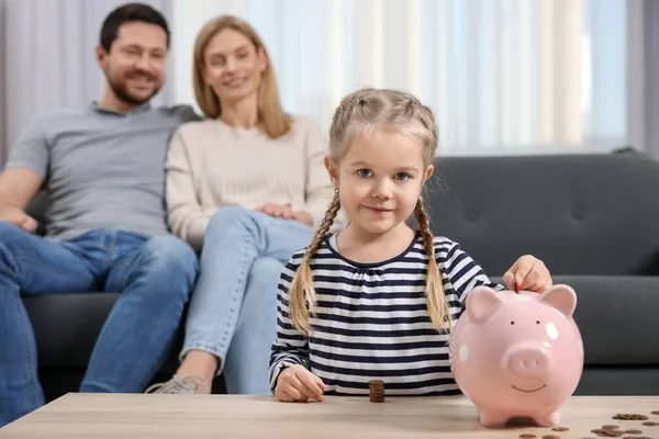 Familiebudget Klein Meisje Zet Munt Spaarvarken Bank Terwijl Haar Ouders — Stockfoto