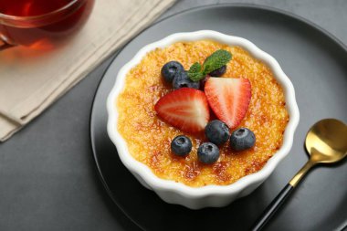 Böğürtlenli nefis creme brulee ve gri masadaki nane şekeri, yakın plan