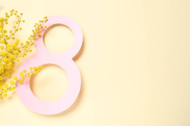 Açık sarı zemin üzerinde mimoza çiçekleri olan 8 Mart tebrik kartı tasarımı, üst manzara. Metin için boşluk