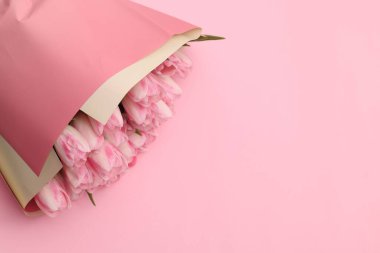 Pembe arka planda güzel bir buket taze lale, üst manzara. Metin için boşluk