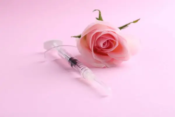 Καλλυντικά Ιατρική Σύριγγα Και Τριαντάφυλλο Λουλούδι Ροζ Φόντο Closeup — Φωτογραφία Αρχείου