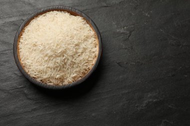 Siyah masa üzerinde çiğ basmati pilavı, üst manzara. Metin için boşluk