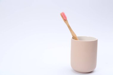 Tutucudaki Bambu diş fırçası beyaza izole edilmiş.