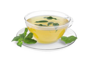 Cam fincanda taze yeşil çay, beyaz üzerinde izole edilmiş nane ve çay tabağı.