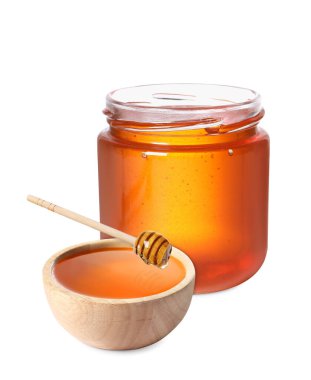Doğal bal, Dipper 'dan ahşap kaseye damlıyor. Beyaz arkaplanda bal dolu kavanoz