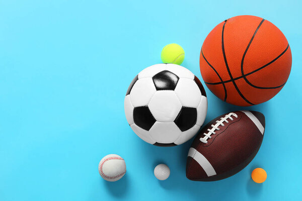 Many different sports balls on light blue background, flat lay. Space for text