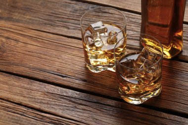 Buzlu viski ve bardaklar ve ahşap masada şişe, yakın plan. Metin için boşluk