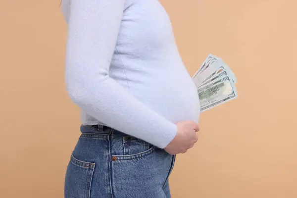 Суррогатная Мать Беременная Женщина Долларовыми Банкнотами Бежевом Фоне Крупным Планом — стоковое фото