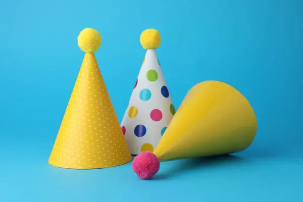 Colorful party hats on light blue background