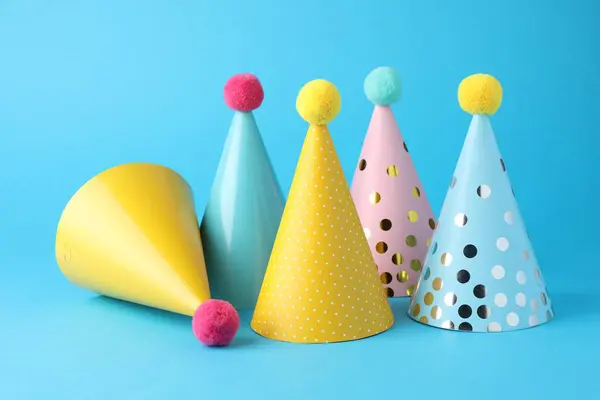 Colorful party hats on light blue background