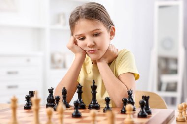 Odada satranç oynayan tatlı bir kız.