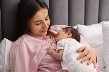 Anne yeni doğmuş bebeğiyle uyuyor.