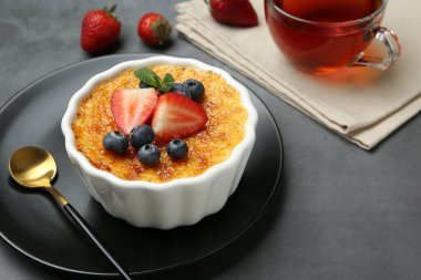 Böğürtlenli nefis creme brulee ve gri masadaki nane şekeri, yakın plan