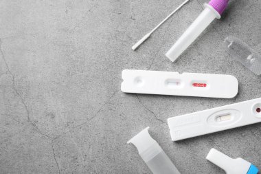 Tek kullanımlık test kitleri gri masada, düz yerde. Metin için boşluk