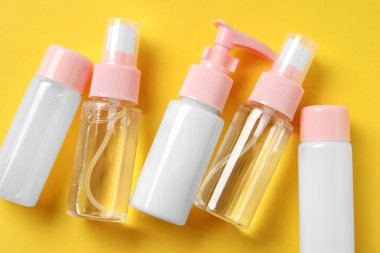 Sarı arka planda kozmetik seyahat seti, düz yatış. Banyo aksesuarları