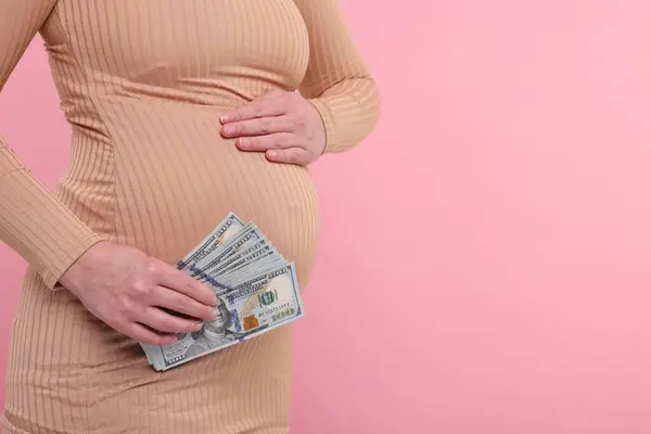Taşıyıcı Anne Pembe Arka Planda Dolar Banknotları Olan Hamile Kadın — Stok fotoğraf