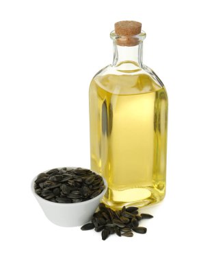 Sebze yağları. Cam şişedeki ayçiçeği yağı ve beyaz üzerine izole edilmiş tohumlar