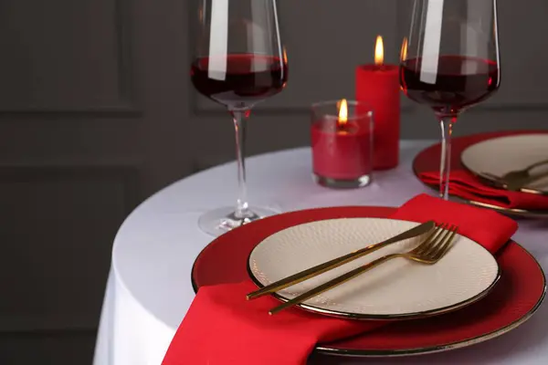 Place setting with candles for romantic dinner on white table, closeup. Space for text