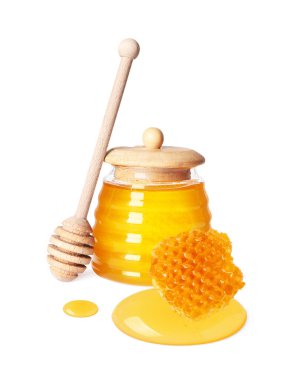 Kavanozda doğal bal, ahşap kaplama ve beyaz arka planda bal peteği.