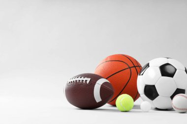 Açık gri arkaplanda birçok farklı spor topu, metin için boşluk