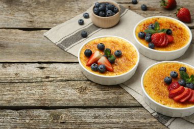Böğürtlenli nefis creme brulee ve ahşap masadaki nane şekerleri. Metin için boşluk