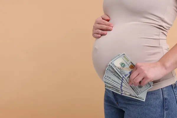Taşıyıcı Anne Bej Arka Planda Dolar Banknotları Olan Hamile Kadın — Stok fotoğraf