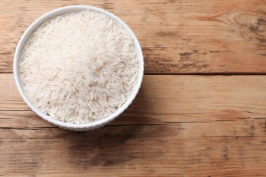 Tabakta çiğ basmati pilavı, ahşap masa, üst manzara. Metin için boşluk