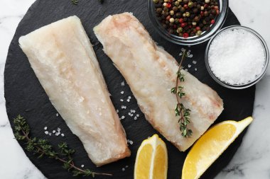 Taze çiğ balık filetoları, baharatlar ve limon beyaz mermer masa, üst görünüm
