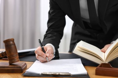 Evraklarla çalışan bir avukat. Kapalı masa, yakın plan.