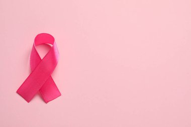 Renk arkaplanı üzerine pembe kurdele, metin için üst görünüm ve boşluk. Göğüs kanseri farkındalığı