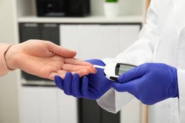 Diyabet. Doktor kan şekerini klinikte glukometreyle ölçüyor.