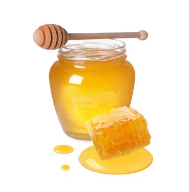 Kavanozda doğal bal, ahşap kaplama ve beyaz arka planda bal peteği.