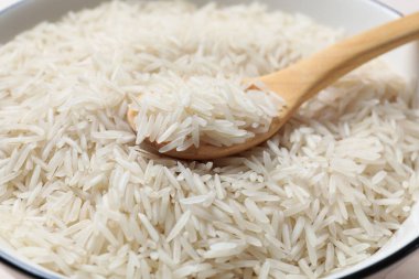 Tahta kaşıklı çiğ basmati pilavı, yakın plan.