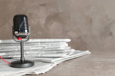 Gazeteler ve antika mikrofon mermer masanın üzerinde. Gazeteci işi.