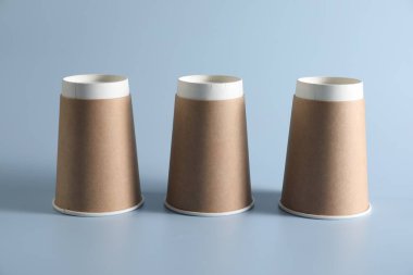 Deniz kabuğu oyunu. Açık mavi arkaplanda üç kağıt bardak