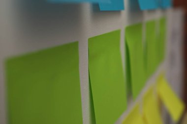 Beyaz tahtada boş yeşil kağıt notlar, yakın plan.