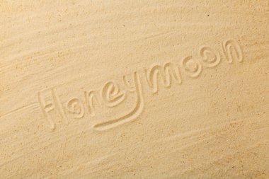 Balayı kelimesi kumda yazılı, en üstte.