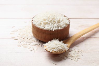 Beyaz ahşap masada pişmemiş çiğ basmati pilavı.