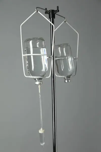 IV infusion set on pole against grey background