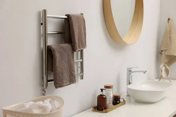 Heated towel rail with brown towels in bathroom