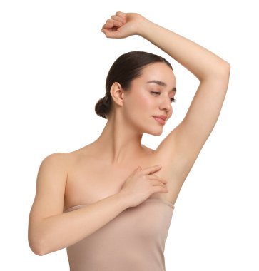 Güzel bir kadın, beyaz arka planda pürüzsüz, temiz bir ciltle koltukaltı gösteriyor.