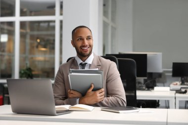 Ofiste çalışan dosyalı mutlu bir adam. Avukat, işadamı, muhasebeci ya da yönetici.